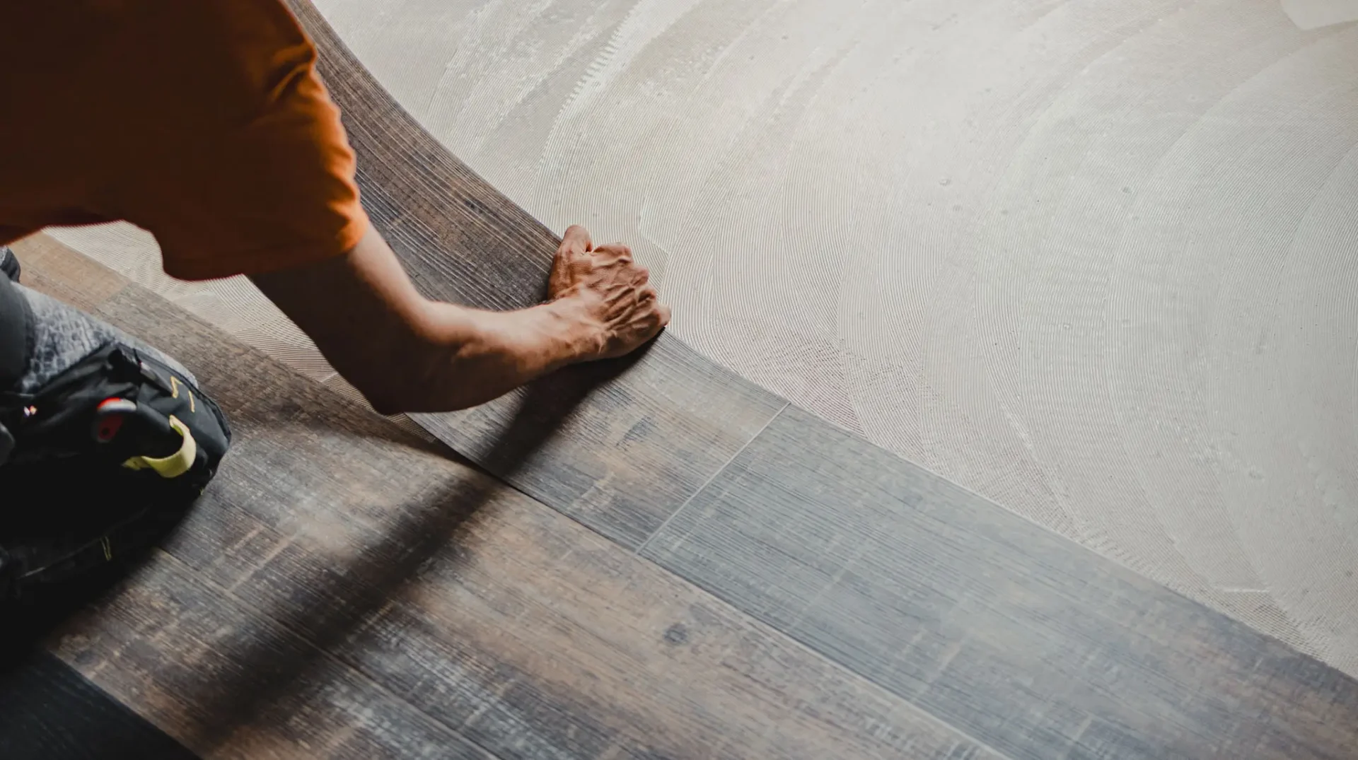Worker installing wood plank flooring
