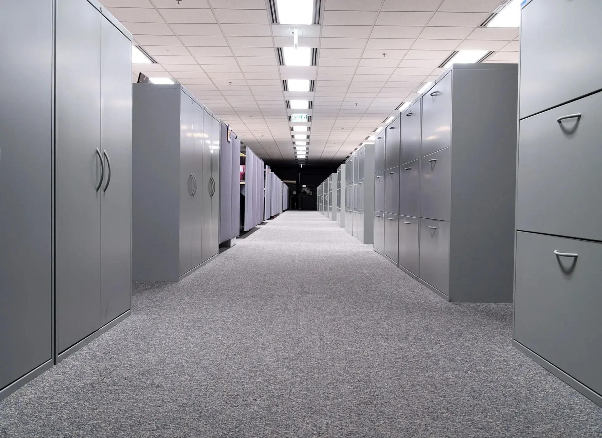 Long office corridor lined with gray filing cabinets